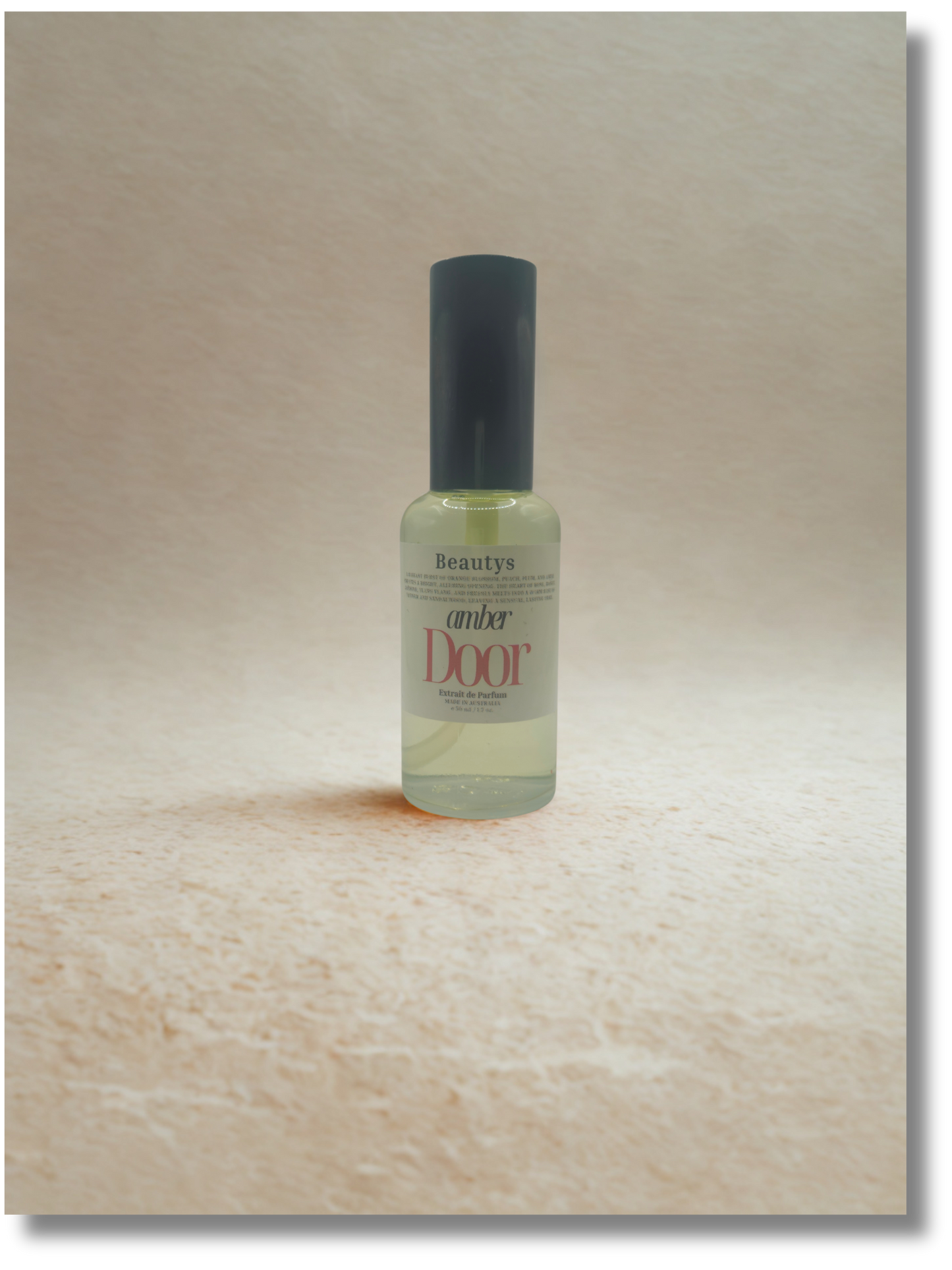 Bottle of 'Amber Door' perfume on a wooden surface
