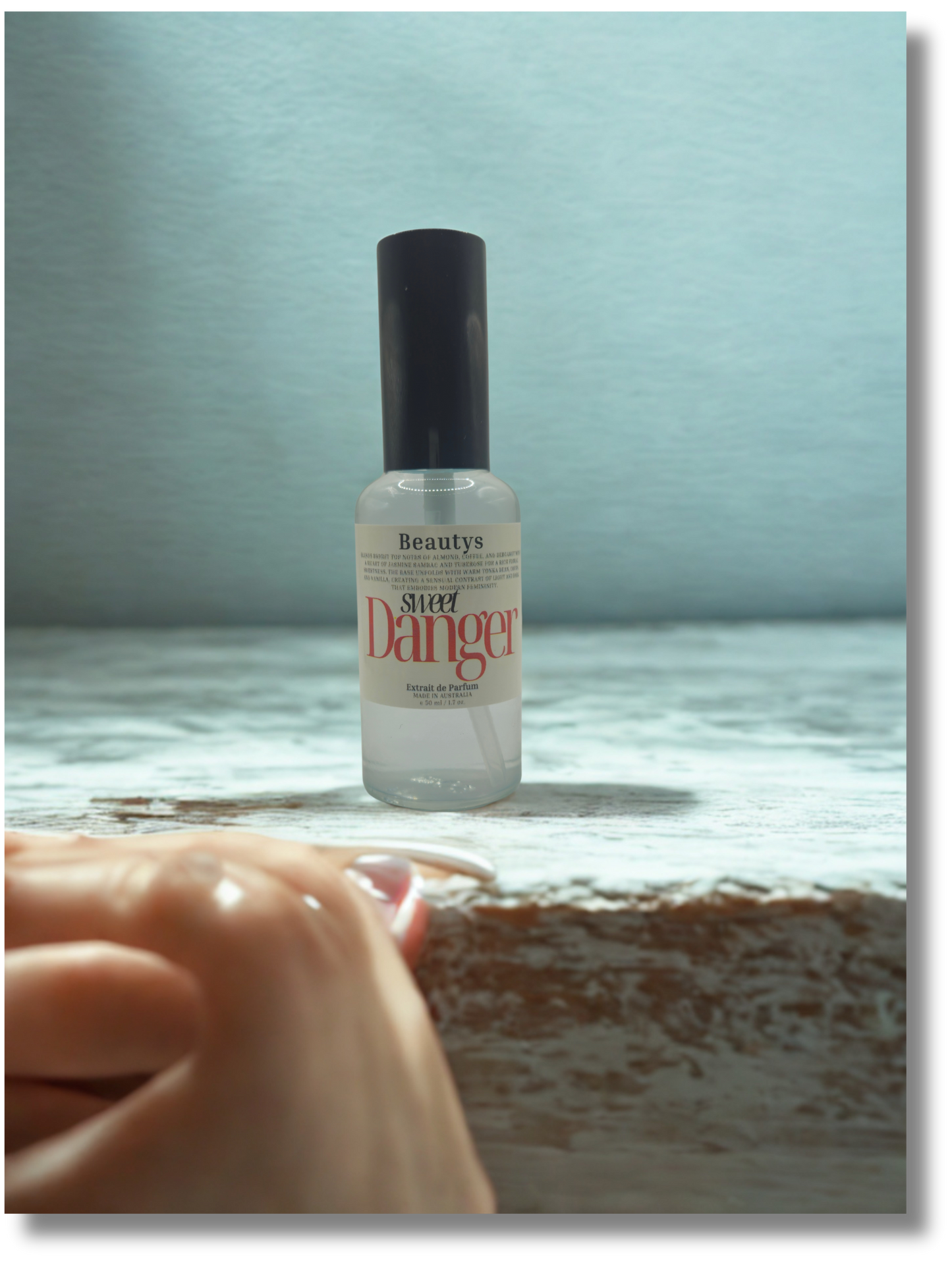 Sweet Danger perfume photographed with florals and soft lighting, elegant women’s fragrance.