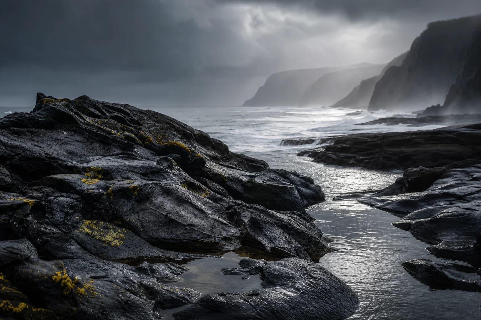Tasmania-inspired rugged coastline with wet dark rock, silver surf, sea mist and small lime-green lichen patches