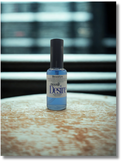 Elegant Moonlit Desire perfume displayed on marble surface, cruelty-free unisex scent.