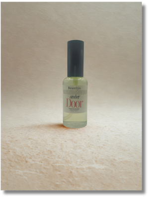 Bottle of 'Amber Door' perfume on a wooden surface