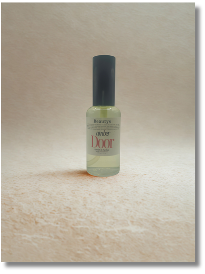 Bottle of 'Amber Door' perfume on a wooden surface