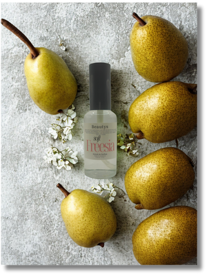Beauty product bottle with pears and flowers on a textured surface