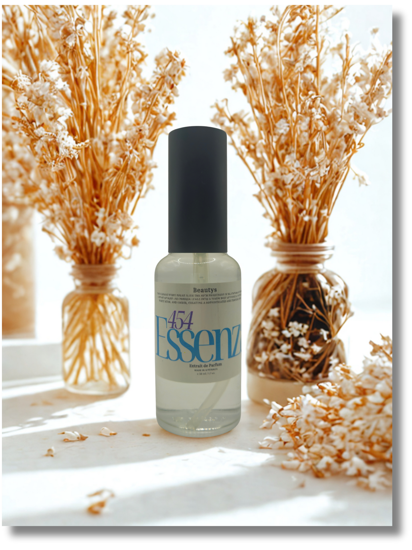 Bottle of Essenz with decorative dried plants on a light background