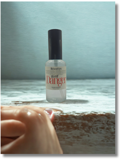 Sweet Danger perfume photographed with florals and soft lighting, elegant women’s fragrance.