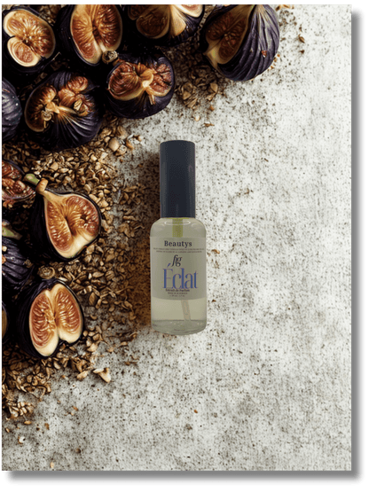 Bottle of 'Eclat' with figs and seeds on a textured surface